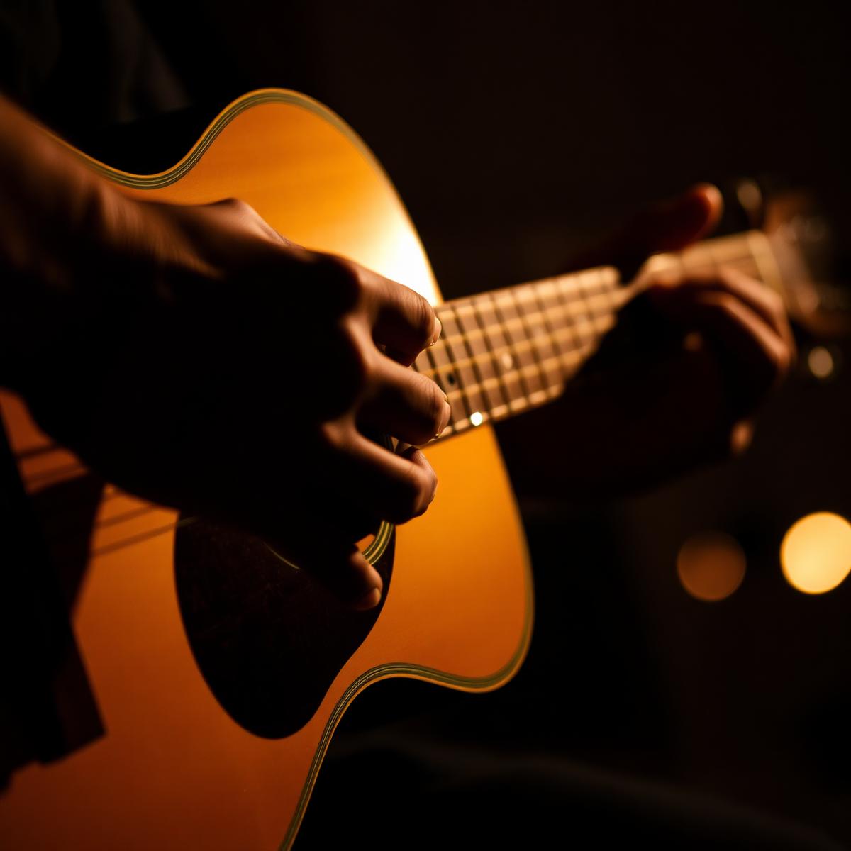 Hands playing acoustic guitar